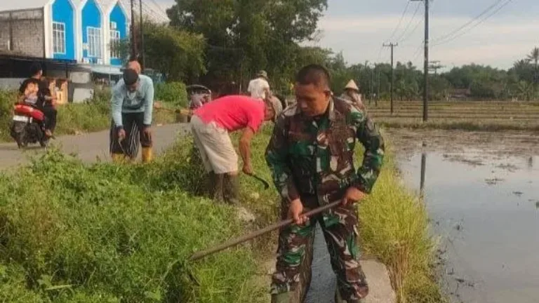 Wujudkan Lingkungan Asri, Babinsa Kodim 1409/Gowa Pimpin Karya Bakti di Jalan Poros Pallangga